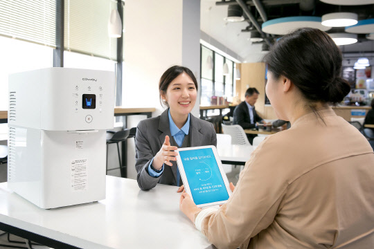 웅진코웨이의 서비스 전문가인 코디가 고객에게 정수기 서비스에 대해 설명하고 있다. <웅진코웨이 제공>